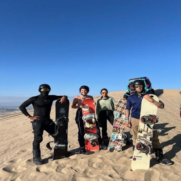 Fotografia de personas realizando sandbording en el desierto de Ica