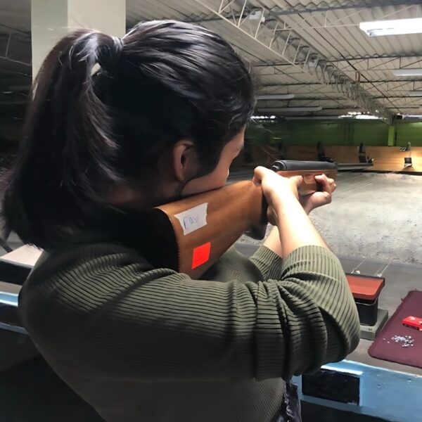 Fotografía de mujer disparando en un polígono