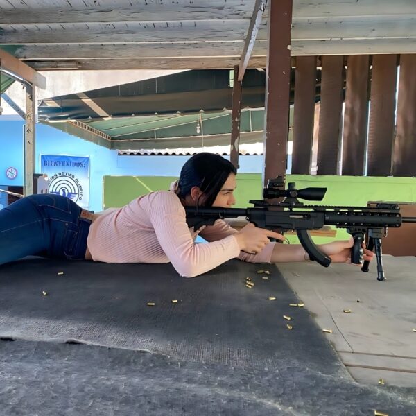 Mujer disparando en un poligono con un rifle