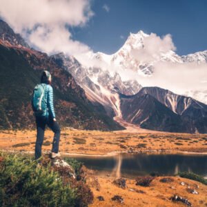 Persona realizando senderismo o trekking en colca en un paisaje montañoso, con un lago y montañas nevadas al fondo