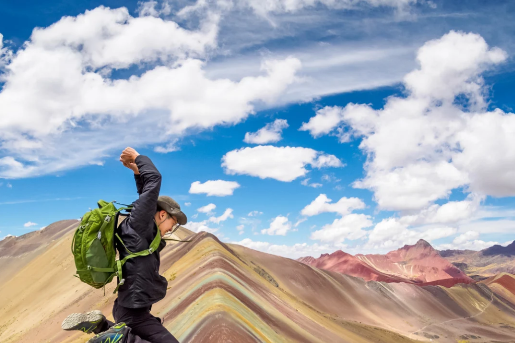 Turista brincando sobre la Montaña de 7 Colores, Cusco