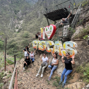 Grupo de turistas posando alegremente junto al letrero colorido de 'I Love Cascas' en el parque de Eco-Aventuras Extremas